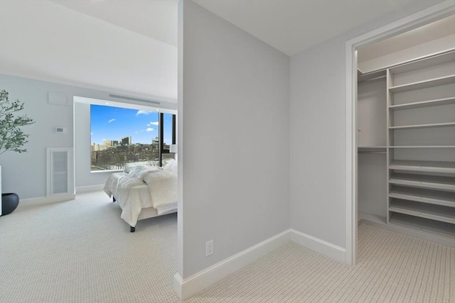 carpeted bedroom with a walk in closet and a closet