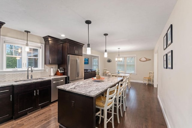 11 Winslow Way, Swansea, MA 02777 - kitchen featuring appliances with stainless steel finishes, a sink, a breakfast bar area, and light stone counters