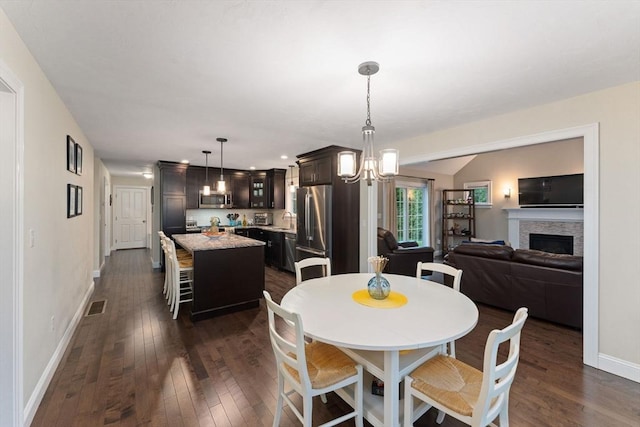 11 Winslow Way, Swansea, MA 02777 - dining space featuring dark wood-type flooring, baseboards, a chandelier, a fireplace, and recessed lighting