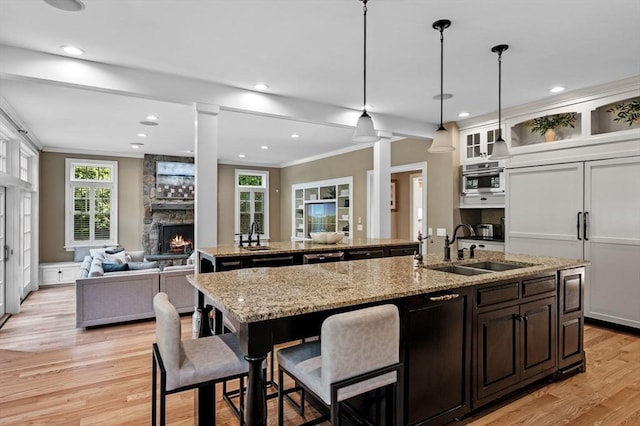 5 Carolina Way, Boxford, MA 01921 - kitchen with a center island with sink, open floor plan, crown molding, light wood-style floors, and a stone fireplace