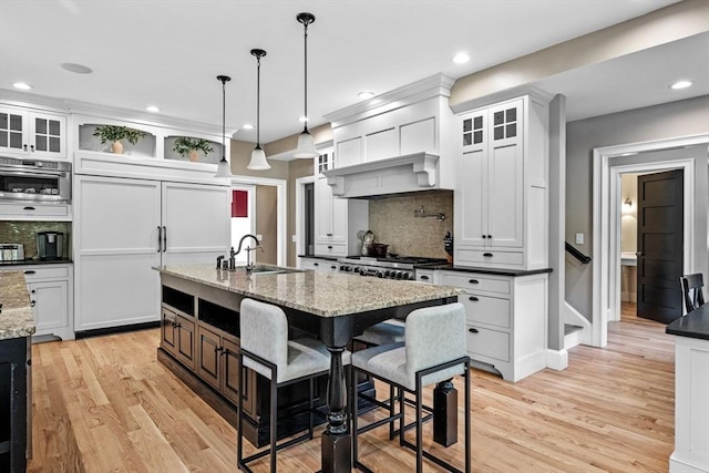 5 Carolina Way, Boxford, MA 01921 - kitchen featuring backsplash, an island with sink, light wood-style flooring, white cabinetry, and recessed lighting