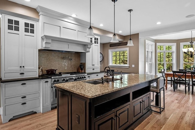 5 Carolina Way, Boxford, MA 01921 - kitchen featuring high end stove, light wood-type flooring, white cabinets, decorative backsplash, and a breakfast bar