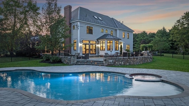 5 Carolina Way, Boxford, MA 01921 - back of house at dusk featuring a chimney, a pool with connected hot tub, a patio, and outdoor lounge area