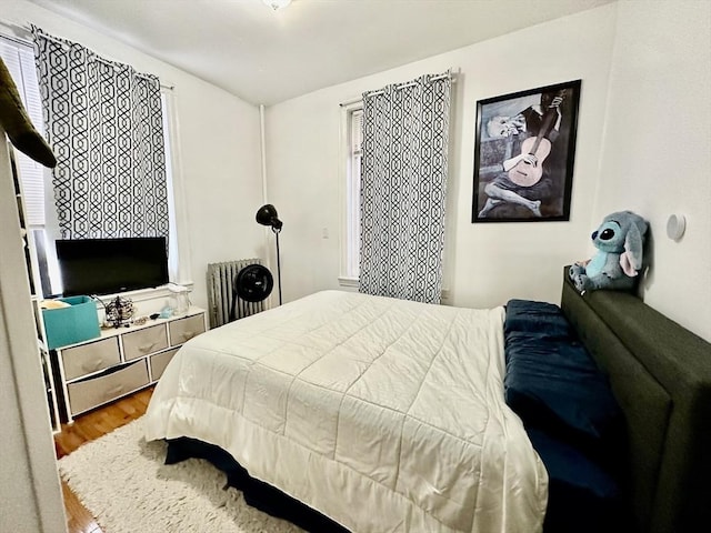 bedroom featuring radiator and wood finished floors