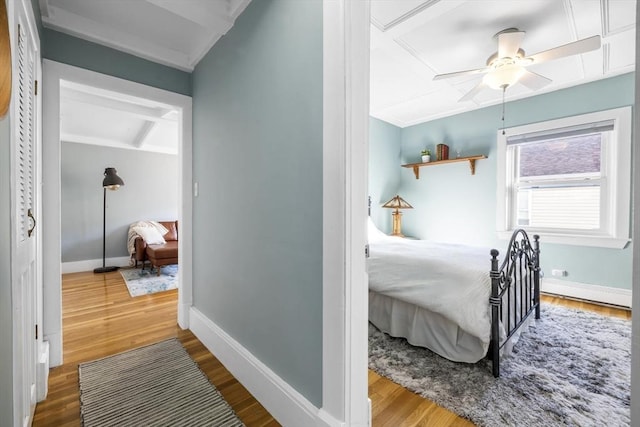 bedroom featuring ceiling fan, a baseboard radiator, and wood-type flooring