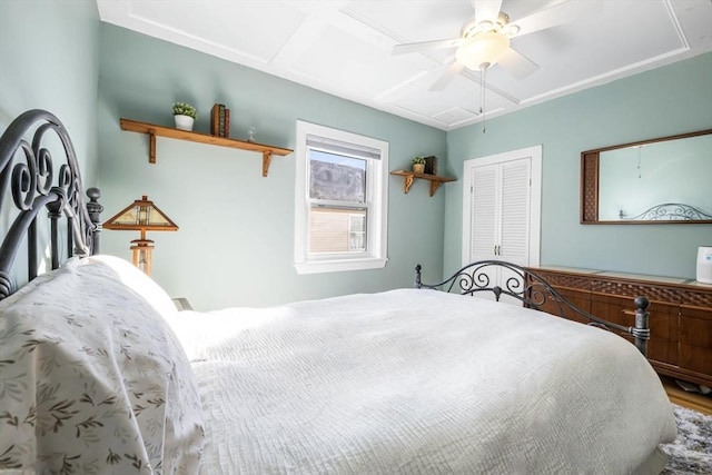 bedroom with hardwood / wood-style floors, a closet, and ceiling fan