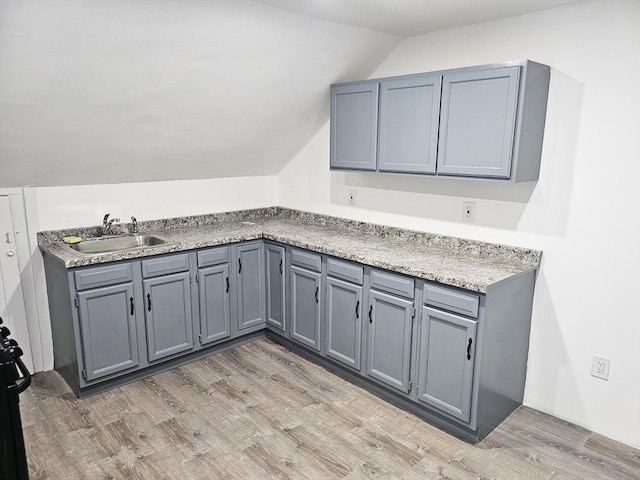 21 High St, South Hadley, MA 01075 - kitchen with vaulted ceiling, light wood-style floors, gray cabinetry, and light countertops