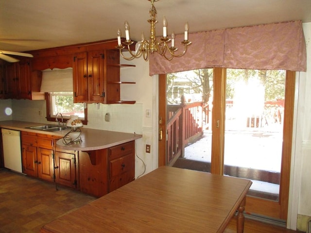 kitchen featuring white dishwasher, sink, ceiling fan with notable chandelier, and tasteful backsplash