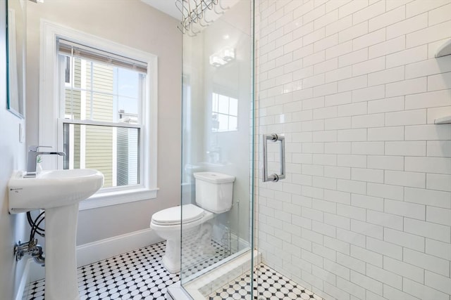 bathroom with tile patterned floors, an inviting chandelier, toilet, and an enclosed shower