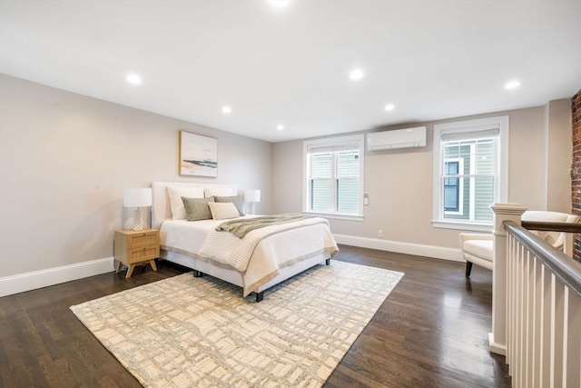 bedroom with dark hardwood / wood-style floors and an AC wall unit