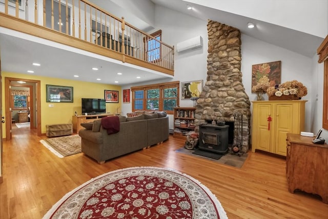 236 Ridge Ave, Otis, MA 01253 - living area featuring a wood stove, high vaulted ceiling, wood finished floors, a wall mounted AC, and recessed lighting