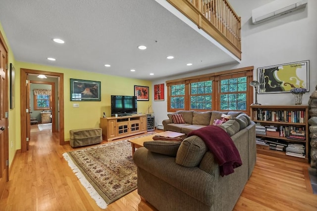 236 Ridge Ave, Otis, MA 01253 - living room with a wall mounted AC, recessed lighting, light wood-style floors, and a baseboard radiator