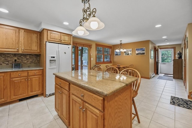 236 Ridge Ave, Otis, MA 01253 - kitchen featuring white refrigerator with ice dispenser, a breakfast bar area, light tile patterned floors, brown cabinets, and recessed lighting