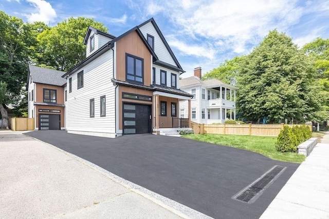 1597 Centre St Unit A, Newton, MA 02461 - view of front facade with a garage, driveway, a metal roof, and a standing seam roof