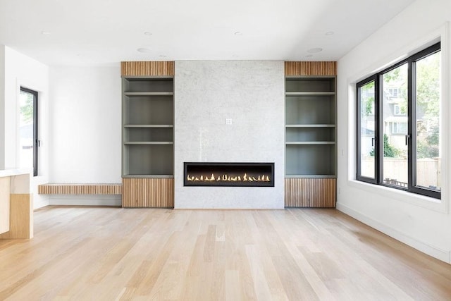 1597 Centre St Unit A, Newton, MA 02461 - unfurnished living room with radiator heating unit, built in features, wood finished floors, and a fireplace