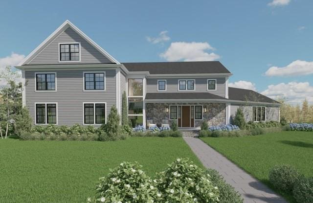 view of front facade with a front yard and stone siding