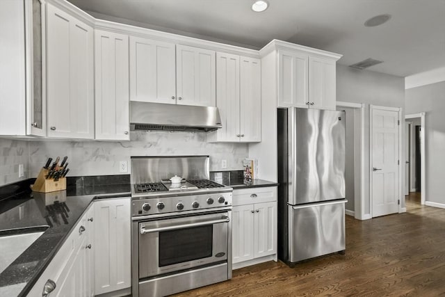 kitchen with under cabinet range hood, appliances with stainless steel finishes, white cabinetry, and dark wood-type flooring