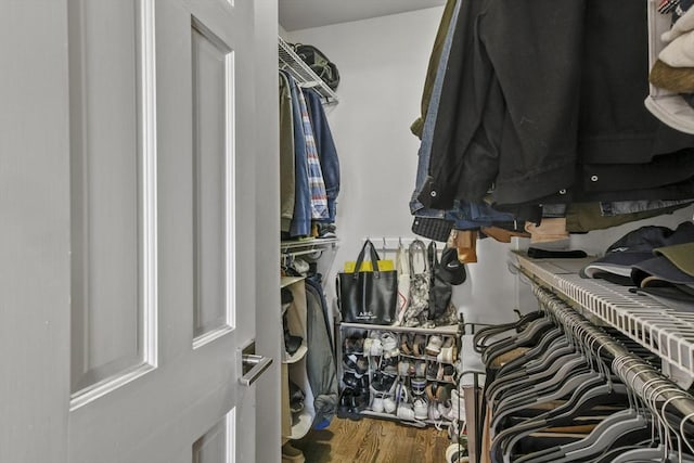 walk in closet with wood finished floors