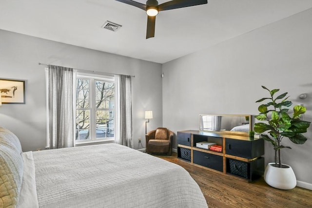 bedroom featuring visible vents, baseboards, wood finished floors, and a ceiling fan