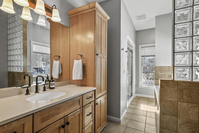 bathroom with tile patterned flooring, visible vents, a shower stall, baseboards, and vanity