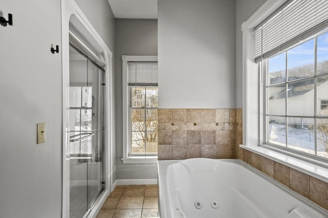 bathroom with tile patterned flooring, a tub with jets, and baseboards