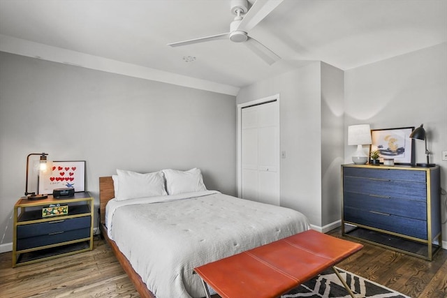 bedroom featuring a closet, baseboards, wood finished floors, and a ceiling fan