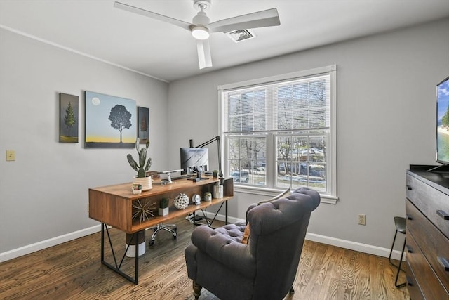 home office with a wealth of natural light, visible vents, baseboards, and wood finished floors