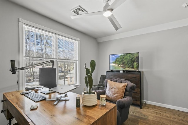 office space featuring visible vents, plenty of natural light, wood finished floors, and a ceiling fan