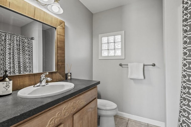 bathroom with tile patterned flooring, toilet, vanity, and baseboards