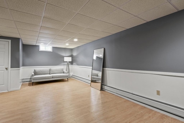 unfurnished living room with wood finished floors and a baseboard radiator