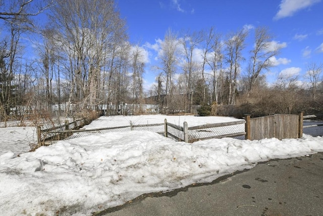 yard layered in snow with a fenced front yard