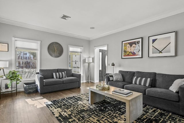 living area featuring visible vents, ornamental molding, baseboards, and wood-type flooring