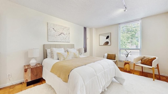 99 Pond Ave Unit 326, Brookline, MA 02445 - bedroom with a textured ceiling, wood finished floors, and baseboards