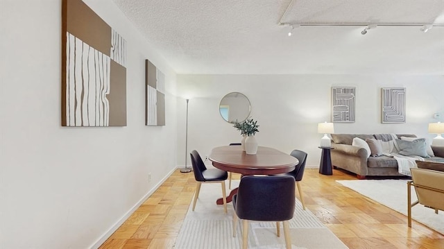 99 Pond Ave Unit 326, Brookline, MA 02445 - dining space with rail lighting, baseboards, and a textured ceiling
