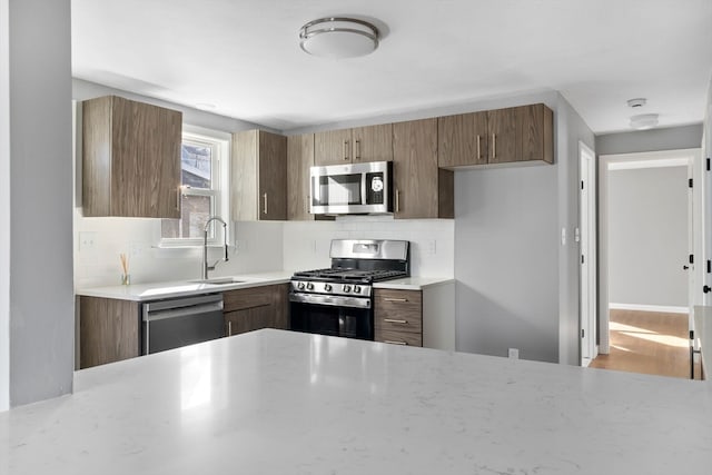 kitchen featuring tasteful backsplash, sink, hardwood / wood-style floors, and appliances with stainless steel finishes