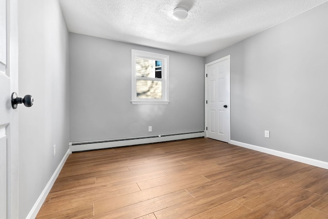 unfurnished room featuring light hardwood / wood-style floors, a textured ceiling, and a baseboard radiator