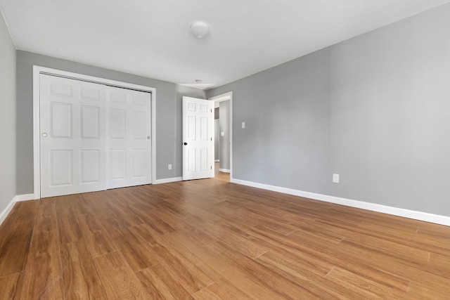 unfurnished bedroom with hardwood / wood-style flooring and a closet