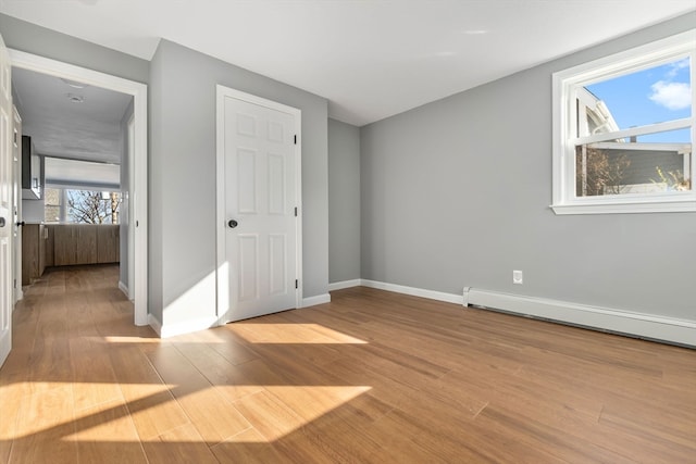 interior space with a baseboard radiator and light hardwood / wood-style flooring