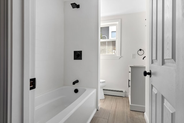 bathroom featuring toilet, baseboard heating, and bathing tub / shower combination