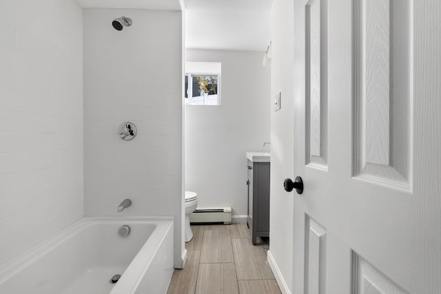 full bathroom with tiled shower / bath, vanity, toilet, and baseboard heating