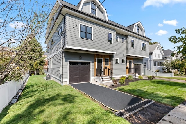 view of front of home featuring central AC unit, a front yard, and a garage