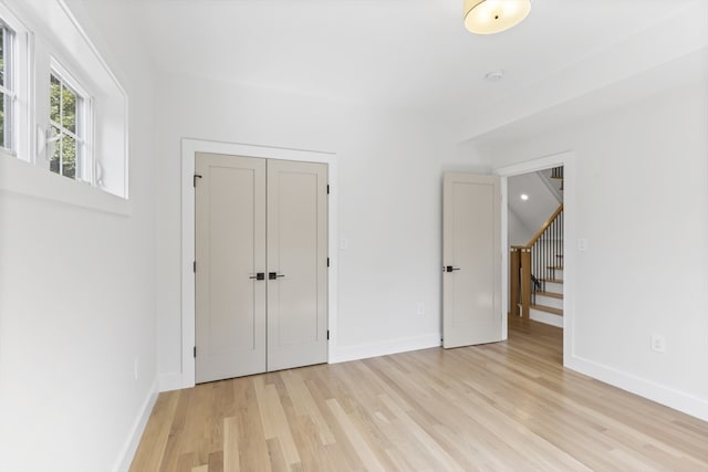 unfurnished bedroom with a closet and light hardwood / wood-style flooring