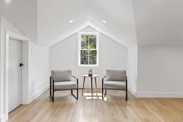 living area with light hardwood / wood-style floors and vaulted ceiling