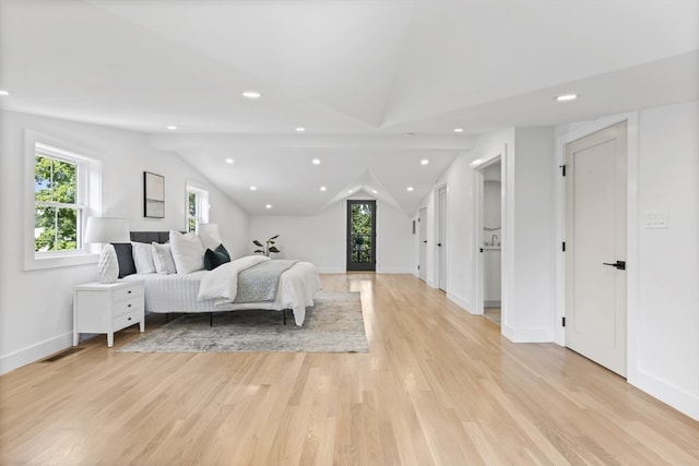 bedroom featuring light wood-type flooring and lofted ceiling