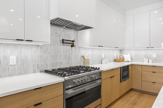 kitchen featuring white cabinets, light hardwood / wood-style flooring, built in microwave, high end stove, and light brown cabinetry