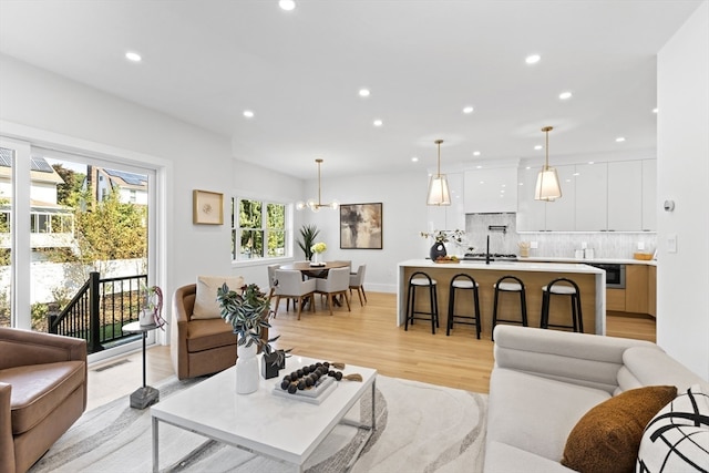 living room with an inviting chandelier and light hardwood / wood-style floors