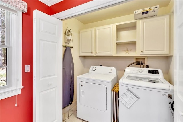 clothes washing area featuring cabinet space, independent washer and dryer, and light tile patterned floors
