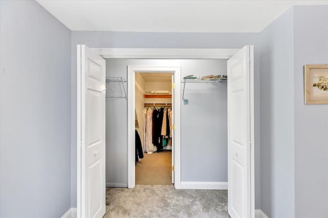 interior space with baseboards and light colored carpet