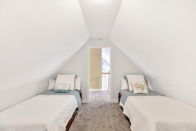 bedroom featuring light colored carpet, baseboards, and lofted ceiling