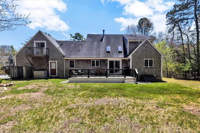 back of property featuring a yard, a shingled roof, a balcony, and a wooden deck